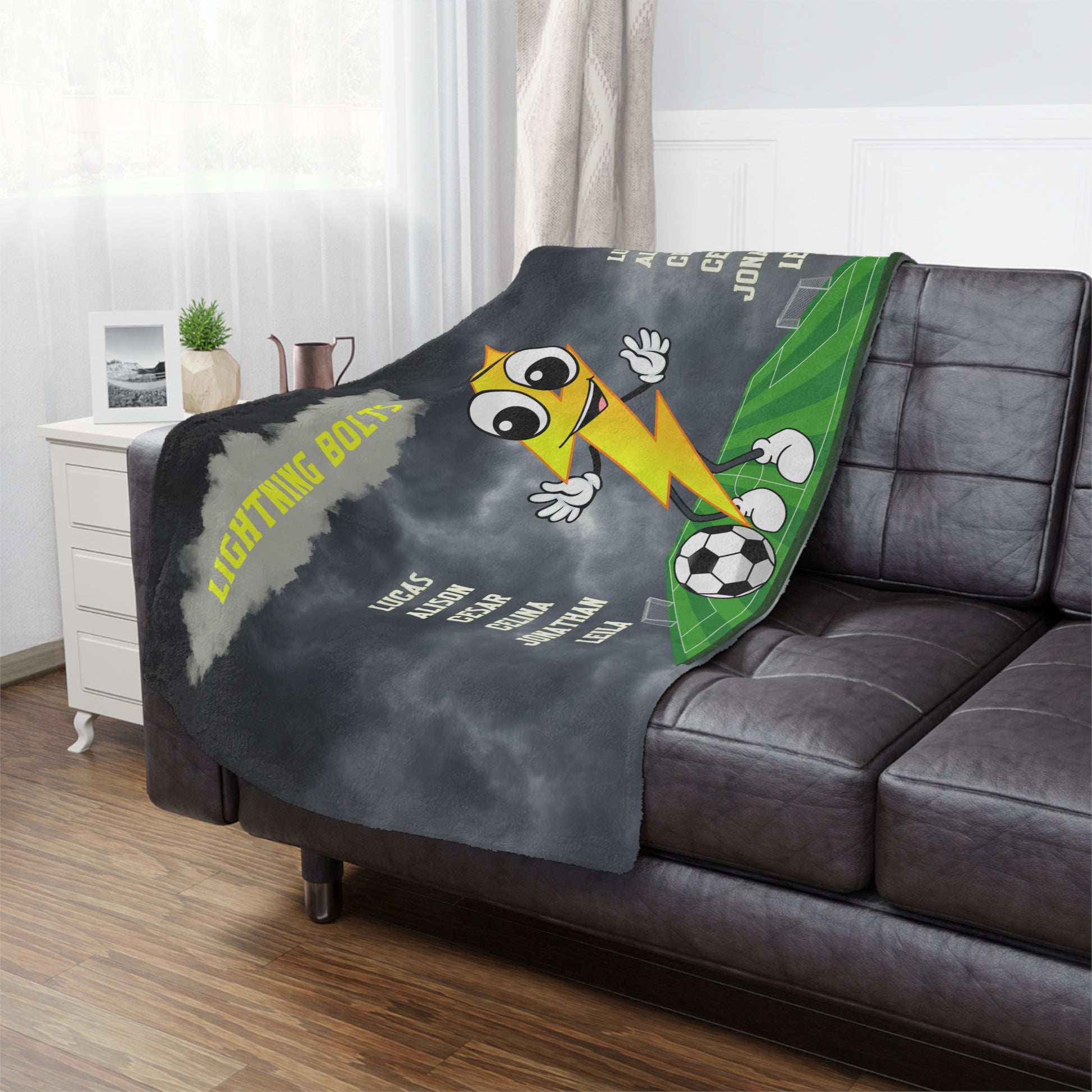 Lightning bolt  soccer team banner blanket hanging on side of brown leather couch