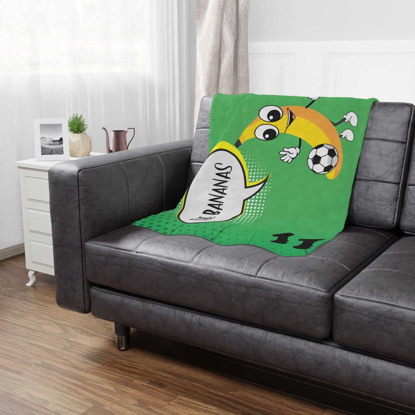 Bananas soccer team banner blanket hanging on side of brown leather couch