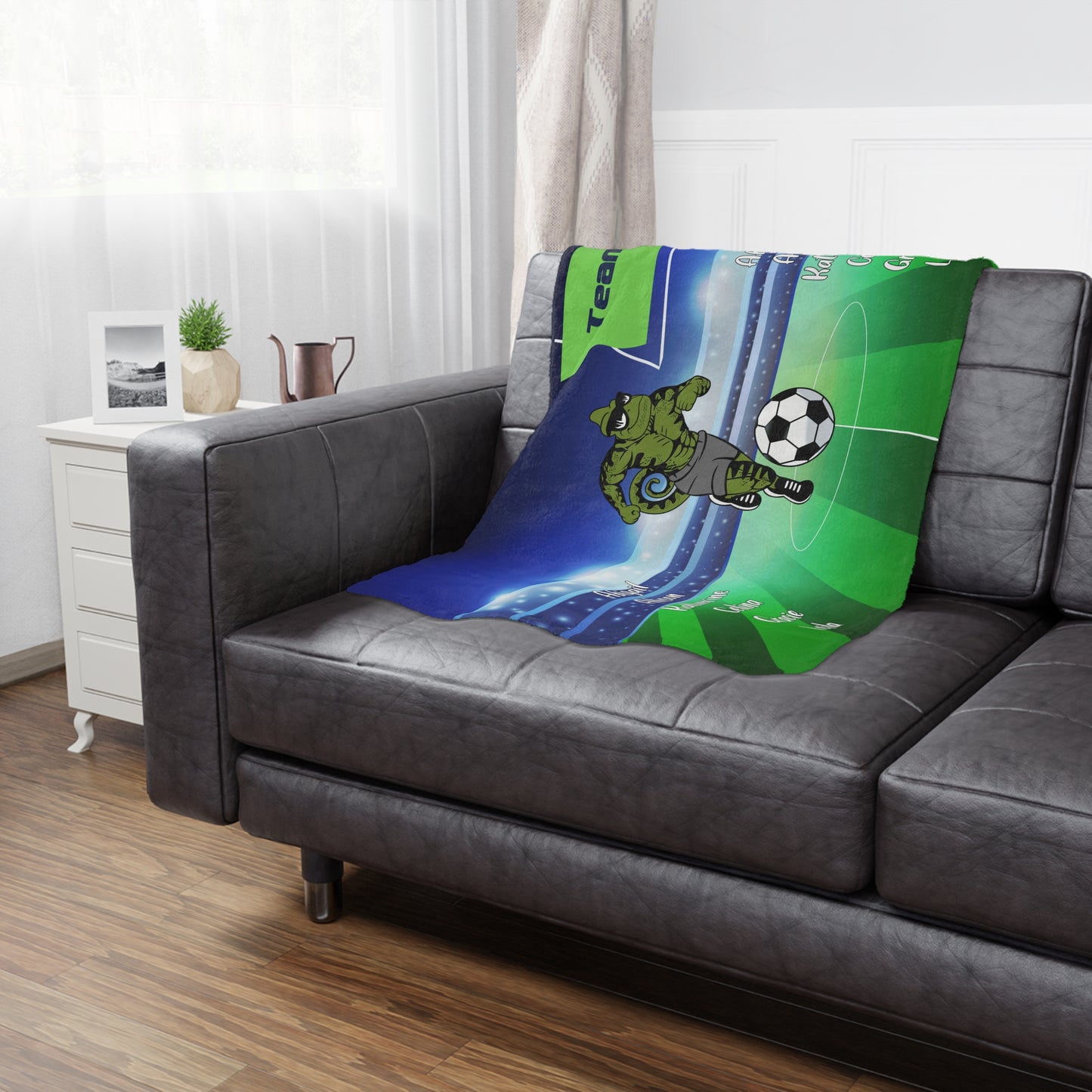 Sample team sports banner blanket with a lizard mascot, draped over a leather coach