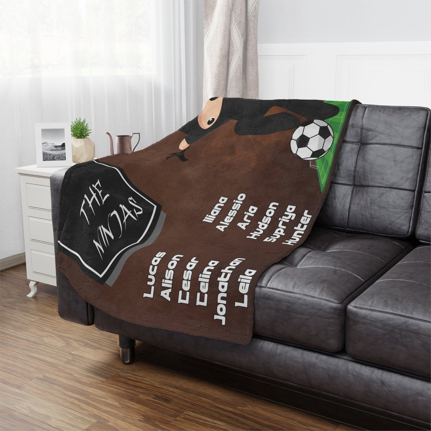 Ninja soccer team banner blanket hanging on side of brown leather couch