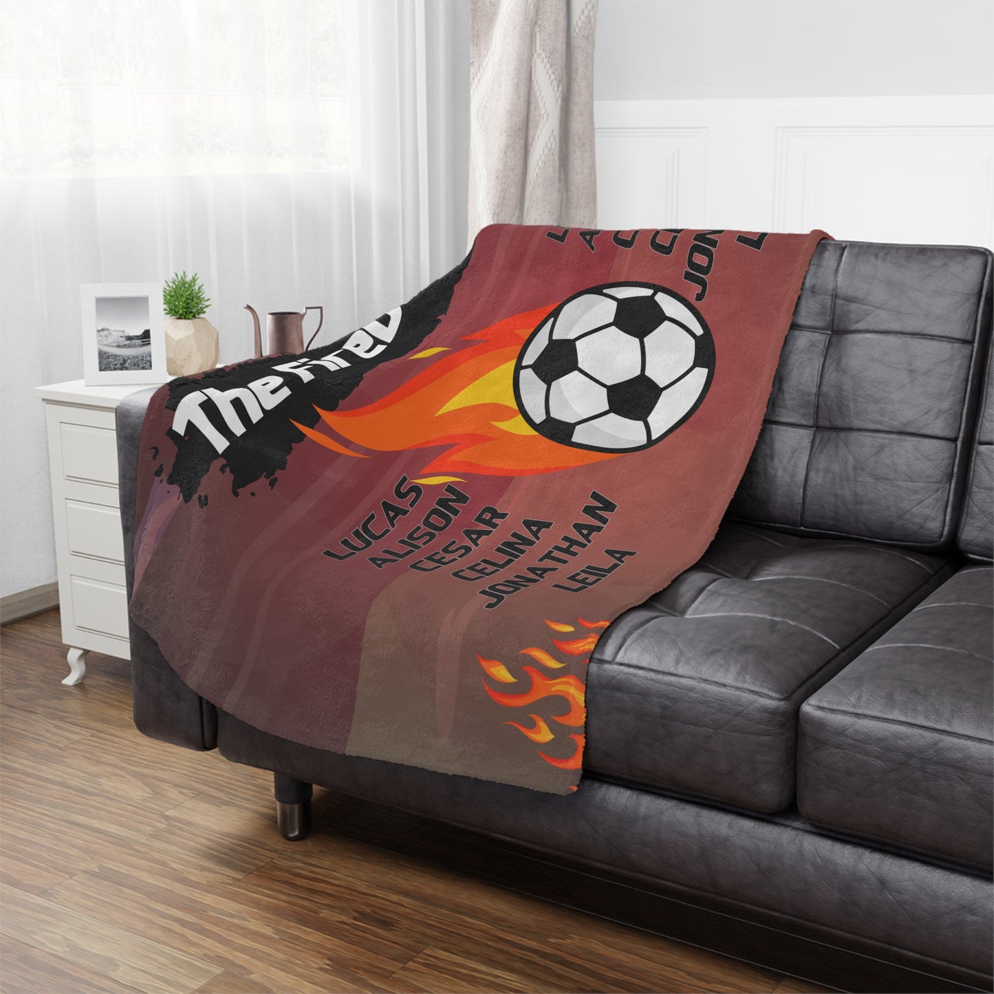 firey soccer ball soccer team banner blanket hanging on side of brown leather couch